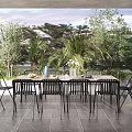 Home Balcony With Outdoor Dining Table Black Chairs And Lush Green Plants