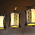 Traditional Chinese Style Chandeliers With Yellow Illuminated Shades And Black Lattice Frames On Textured Wall