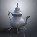 Silver Carved Teapot With Lid Curved Spout And Three Feet On Smooth Dark Surface