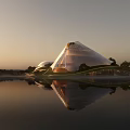 Modern Museum Building with Glass Pyramid Structure and Water Reflection at Sunset Surrounded by Trees