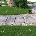 Beautiful Garden Flowers in Landscaped Yard with Curved Stone Path Green Grass Rocks and Pebbles