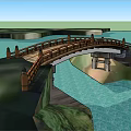 Curved Wooden Landscape Bridge With Railing Lamp Posts Over Blue Water And Green Grass