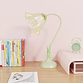 Transparent Petal Shaped Table Lamp With Green Stem Base And Books Alarm Clock On Desk