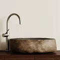 Natural Stone Washbasin With Silver Curved Faucet On Wooden Countertop Against Light Colored Wall