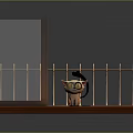 Small Cat Doll On Wooden Platform With Glass Partition And Metal Railing