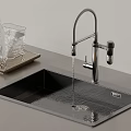 Modern Kitchen Faucet With Running Water Over Black Stainless Steel Sink And Glassware Tray