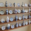 Traditional Blue and White Ceramic Vessels with Vases and Plates Displayed on Wooden Shelves