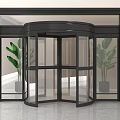 Modern Revolving Door Interior With Glass Panels Black Frame And Green Plants