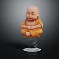Little Monk Statue In Yellow Robe Sitting Cross Legged On Spring Base