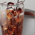 Refreshing Cold Brown Beverage with Ice Cubes in Glass and Empty Glass on Metal Tray