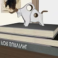White Bull Sculpture with Brown Horns and Spots on Stacked Books for Indoor