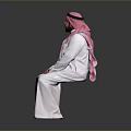 Man In Traditional White Robe With Pink Headscarf Sitting On Gray Background