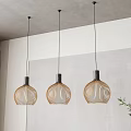 Three Modern Pendant Lights With Woven Design Hanging In Interior Space