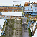 Rusted Industrial Equipment Structure With Yellow Guardrails Metal Platform And Pipes On Concrete Floor