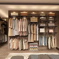 Organized Wardrobe With Multiple Clothes Hangers And Folded Garments On Shelves