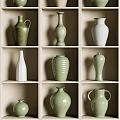 Ceramic Vessels in Green and White with Various Shapes on Display Shelves