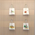 White Lifestyle Tote Bags With Different Patterns Hanging On Wooden Perforated Board