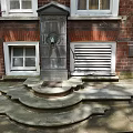 Stone Fountain With Stepped Base Against Brick Wall And White Framed Windows