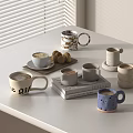 Various Coffee Mugs With Cookies On White Table And Book Background 3d model
