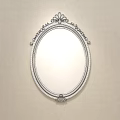 Oval Mirror with Gold and Black Ornate Frame Reflecting Bed and Striped Wall