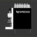 Silver Nespresso Coffee Machine With Stainless Steel Design And Coffee Cups On Top