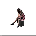 Little Girl in pink dress with white patterns sitting on black cube wearing blue sneakers