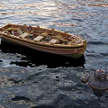 Wooden Boat Floating On Calm Sea Water With Buoy And Ripples On Surface