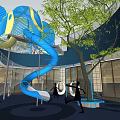 Indoor Playground Space With Blue Spiral Slide Yellow Accents Trees And Open Design