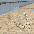 Construction Site With Sprinkler System Spraying Water On Sandy Ground Near Gray Wall