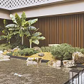Serene Courtyard Garden With Banana Plants Water Pond Rocks And Wooden Panel Wall