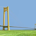 Yellow Suspension Bridge With Tall Towers Against Blue Sky And Green Grass