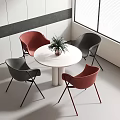 White Round Table with Red and Dark Gray Chairs and Potted Plant in Modern Interior