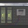 Open Hard Case With Foam Interior Containing Two Green Batteries White Device And Colored Wires
