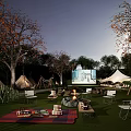Cozy Camping Campsite With Tents Bonfire Outdoor Screen And Picnic Setup At Night