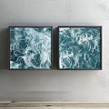 Two Framed Blue Ocean Wave Artworks Hung On Gray Wall