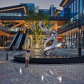 Modern Urban Commercial Street With Glass Facades Sculpture Escalators And Evening Pedestrians