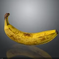 Ripe Yellow Banana With Brown Spots On Black Surface Showing Clear Reflection