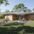 Modern Circular Wooden Community Building With Green Lawn And People Walking Nearby