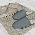 Three Pairs of Gray Fabric Slippers on Gray Woven Mat