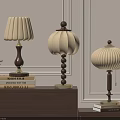 Three Table Lamps With Wooden Bases And Lampshades On Cabinet With Books And Green Plant