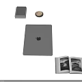 Silver Apple Laptop on Desk with Books Coaster and Open Magazine