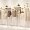 Elegant Golden Clothes Rack Displaying Dresses With Potted Plants And Handbags