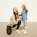 Mother And Child Smiling As Child Points Up In Bright Indoor Room With Light Floor