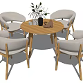 Modern Round Wooden Dining Table With Four Light Gray Fabric Chairs And Decorative Vase