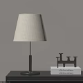 Modern Table Lamp With Metal Base And Fabric Shade Near Black Candlestick And Books