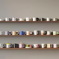 Colorful Mugs With Various Designs Arranged On Wall Shelves