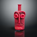 Red Face Shaped Ceramic Vessel With Artistic Eye And Mouth Design On Dark Surface