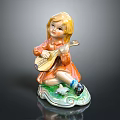 Cute Blonde Child Doll Playing Lute In Orange Dress On Green Base