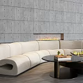 Curved Beige Sofa And Black Round Coffee Table With Fruits Book Fireplace Gray Perforated Wall