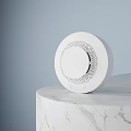 White Circular Commercial Equipment With Perforated Design On Marble Surface And Light Blue Backdrop